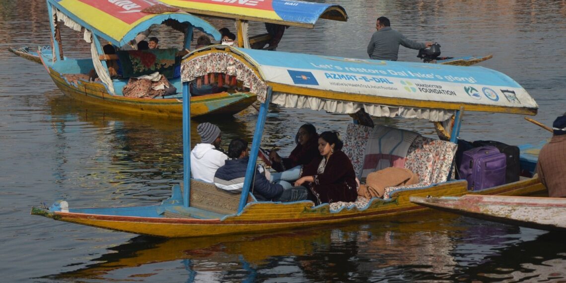Tourists enjoy a serene Shikara ride on Dal Lake amidst crisp winter chill of January in Kashmir