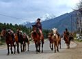 Horsemen riding their horses in renowned tourist destination, Pahalgam in south Kashmir