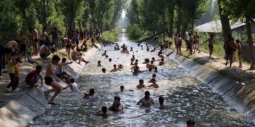 Youth beating the heat in a water canal in Chattergam area of central Kashmir’s Budgam district
