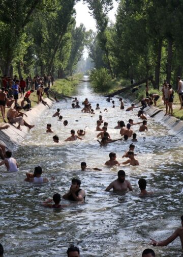 Youth beating the heat in a water canal in Chattergam area of central Kashmir’s Budgam district